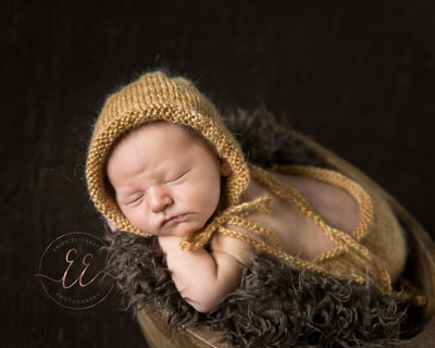 Newborn baby wearing a knitted outfit in yellow. Newborn photography in St Neots, Huntingdon, Cambridgeshire
