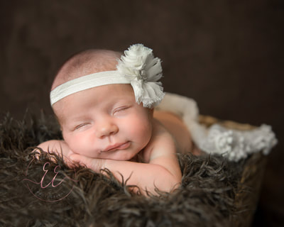 Posed newborn baby with head band. Newborn photography in St Neots, Huntingdon, Cambridgeshire