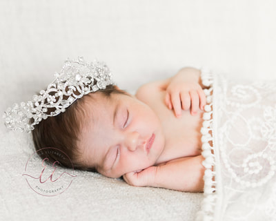 Newborn baby wearing wedding tiara. Newborn photography in St Neots, Huntingdon, Cambridgeshire