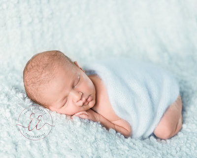 Newborn baby in baby blue wrap. Newborn photography in St Neots, Huntingdon, Cambridgeshire