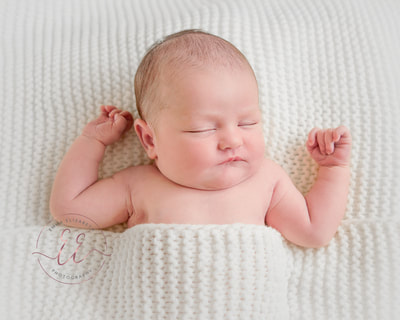 baby wrapped in knitted blanket Newborn photography in St Neots, Huntingdon, Cambridgeshire